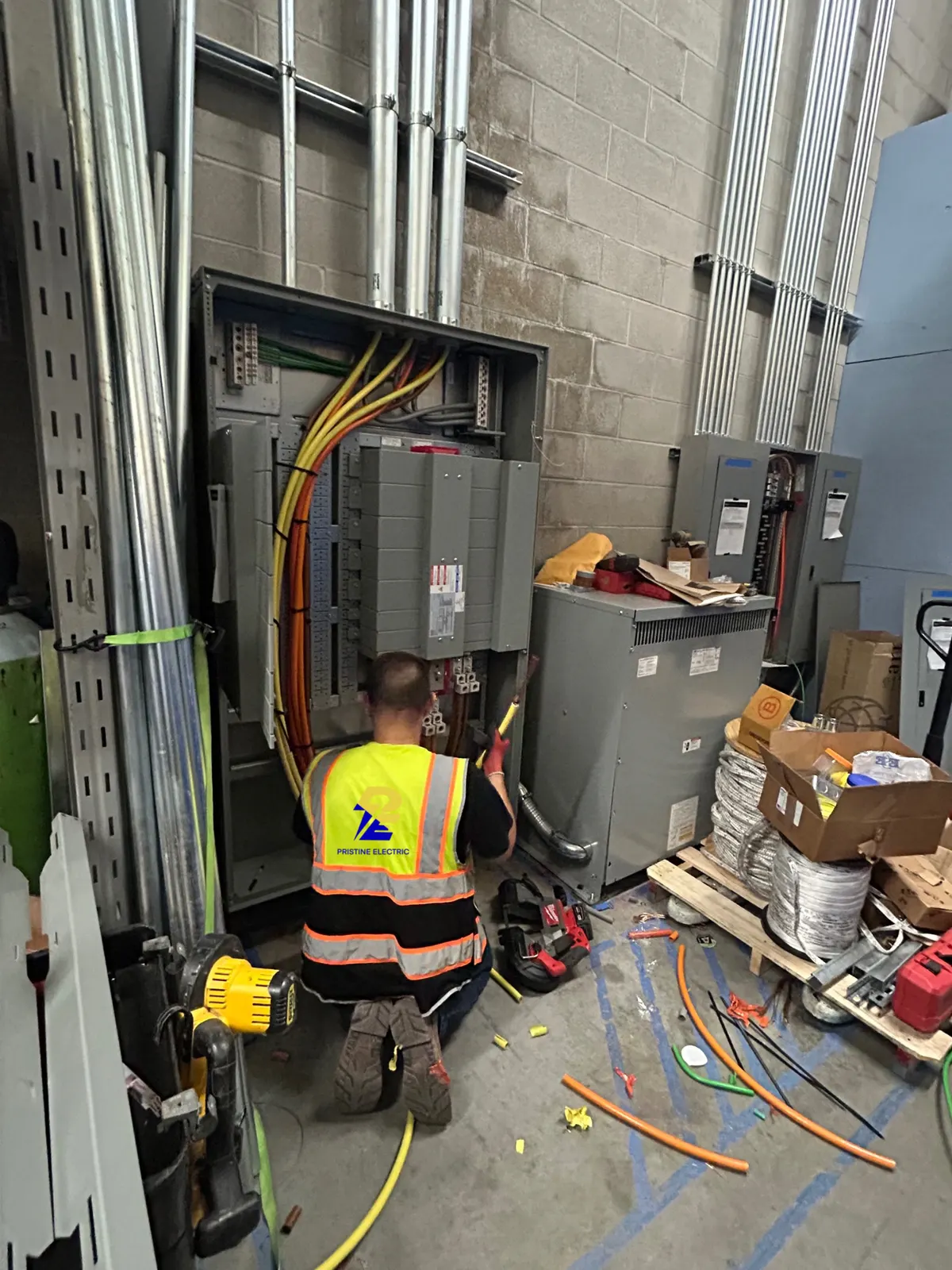 Pristine Electric electrician installing switchgear and conduit in a commercial electrical room